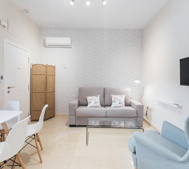 Apartamento Standard Sala de estar com sofá de dois lugares, poltrona e televisão fixada na parede