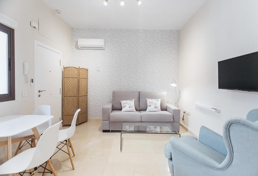 Apartamento Standard | Sala Sala com sofá cinzento e poltrona azul, com TV, mesas e cadeiras