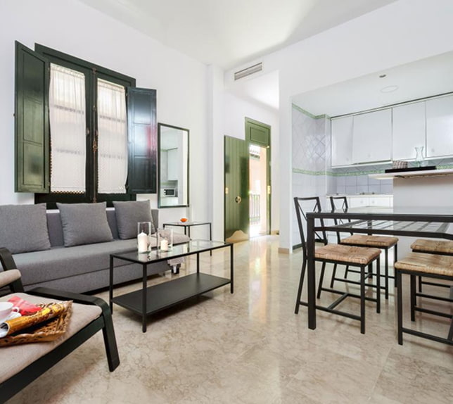 Apartamento Superior Ampla sala de estar, decorada em tons de branco e verde, com cozinha integrada