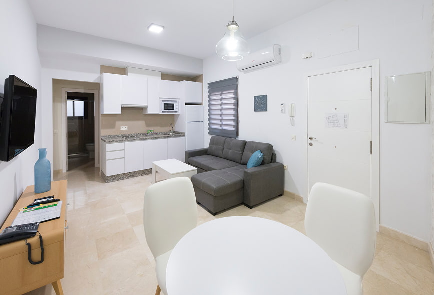Apartamento Superior | Sala 2 Sala com sofá cinzento e cozinha integrada na mesma divisão