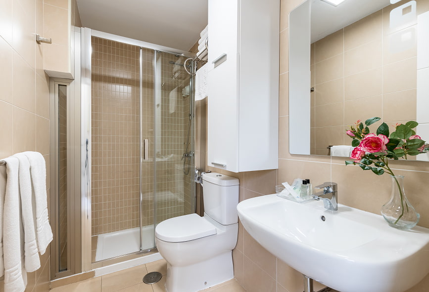 Duplex de 2 quartos com varanda | Casa de banho Casa de banho com duche, lavatório, espelho e um móvel suspenso.