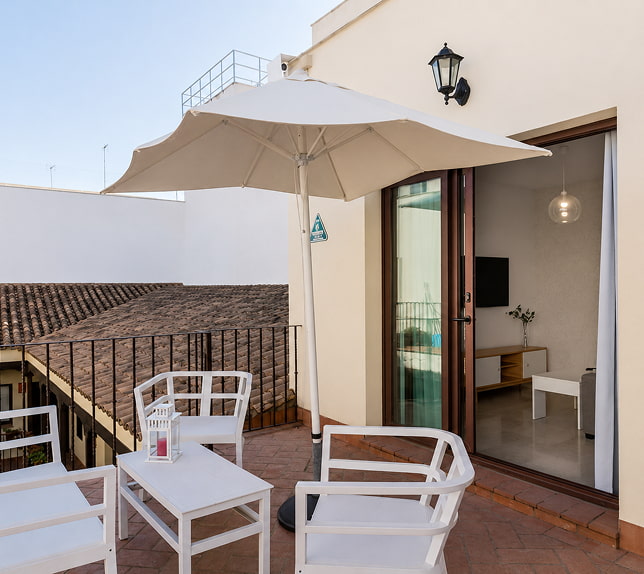 Duplex de 2 quartos com terraço Amplo terraço com mobiliário de exterior e guarda-sol