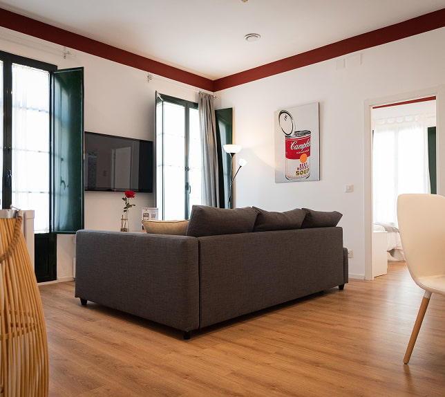 Suite Ampla sala com sofá, TV, soalho em parquet e acesso às varandas
