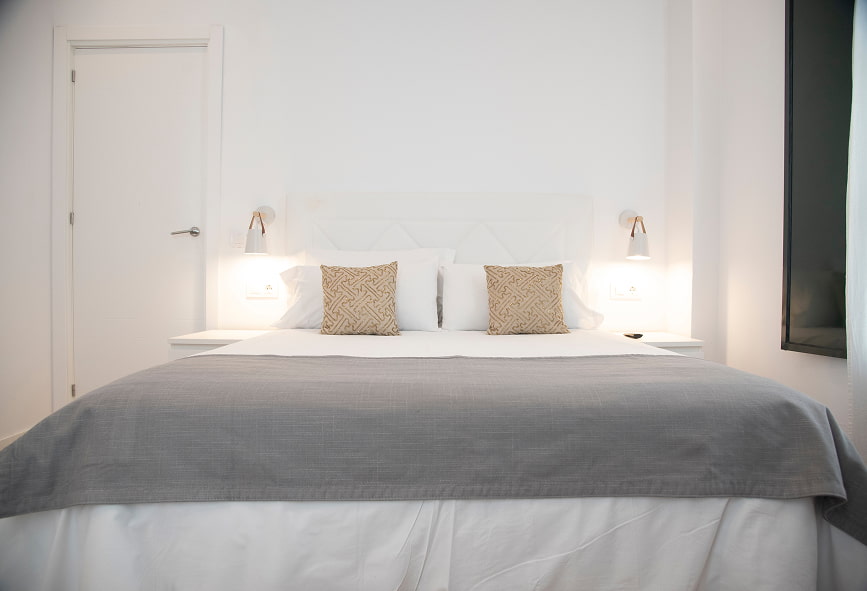 Apartamento Suite | Cama de Casal 2 Primeiro plano da cama de casal com 2 mesas de cabeceira