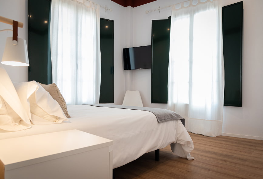 Apartamento Suite | Janelas amplas Quarto espaçoso com duas grandes janelas que conferem luminosidade ao espaço