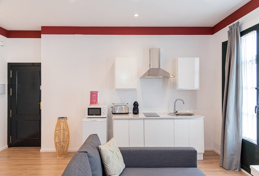 Apartamento Suite | Cozinha Cozinha integrada na sala, com frigorífico pequeno, micro-ondas, torradeira, máquina de café e placa vitrocerâmica
